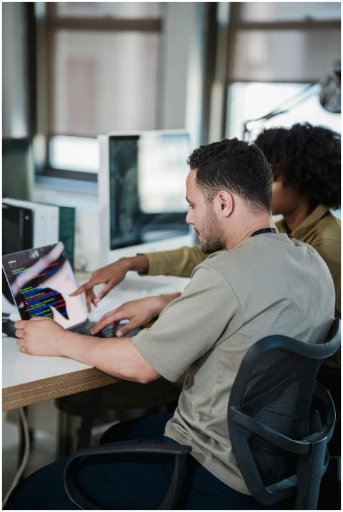 A diverse team collaborating on coding in a modern