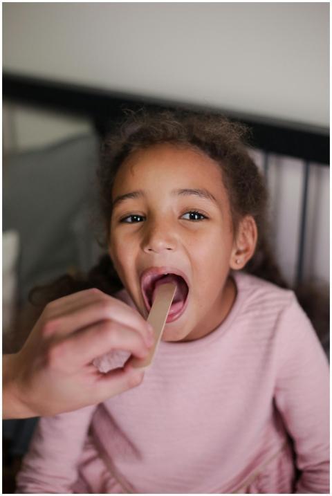 A young girl having her throat examined during a h