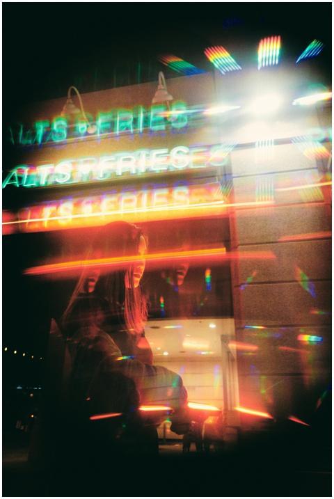 Blurred neon lights reflecting in a city street sc
