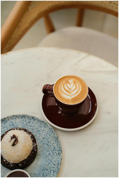 Elegant cappuccino with latte art and dessert on m