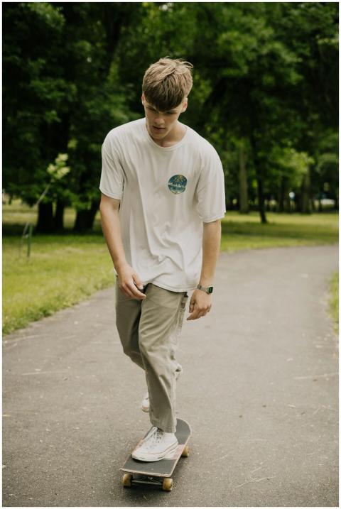 Teenage male skateboarder rides through a peaceful
