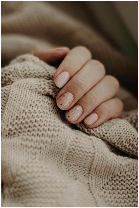 Close-up of a hand with polka dot manicured nails