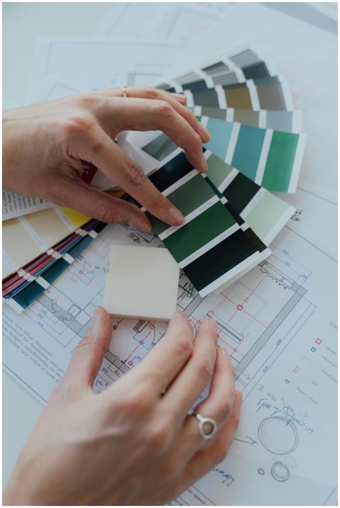 Hands selecting color samples over architectural p