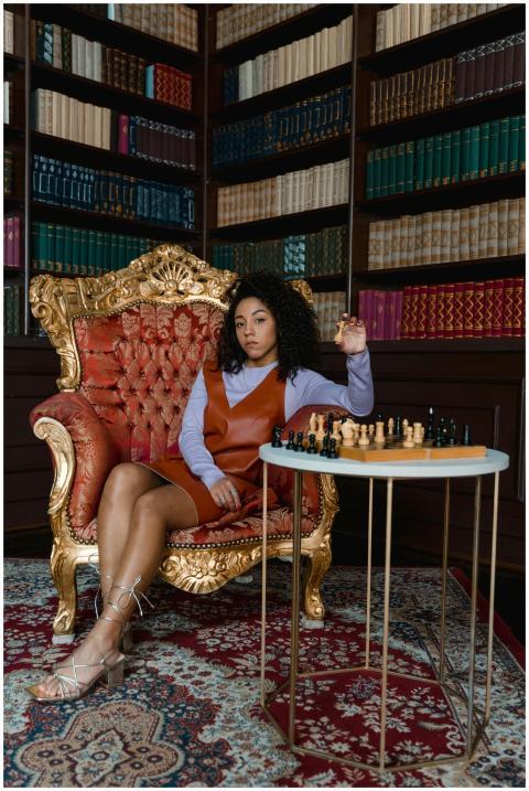 A thoughtful woman sitting in a luxurious library