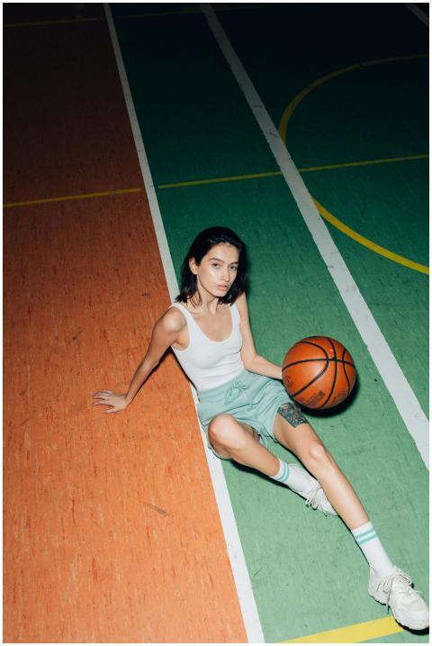 A young woman in a tank top sits on an indoor bask