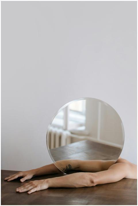 Artistic shot featuring tattooed arms reflected in