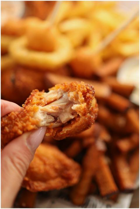 Delicious fried chicken wing being held, perfect f