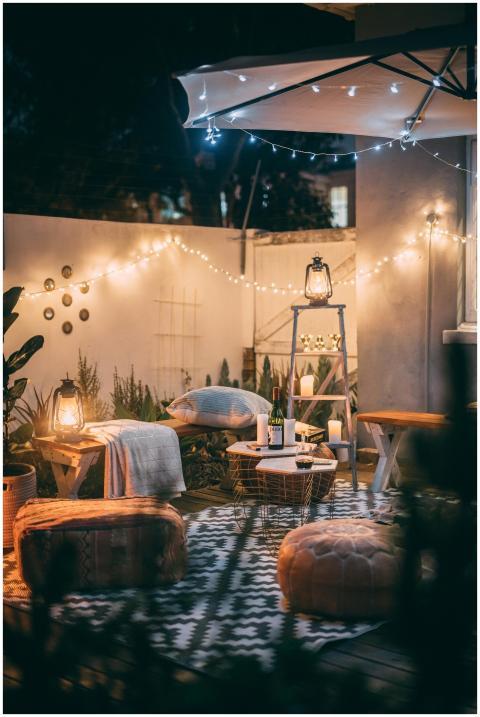 Warmly lit outdoor patio with cozy seating, lanter