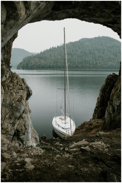 Sailboat docked in a serene river setting, framed