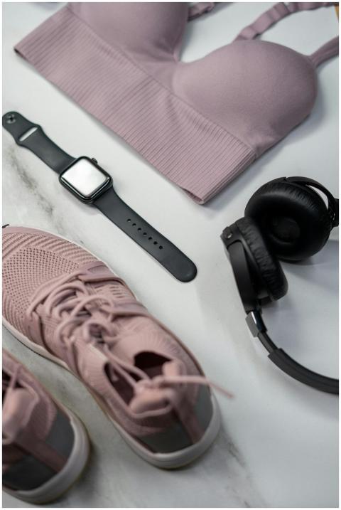 Flat lay of gym essentials with pink sportswear an