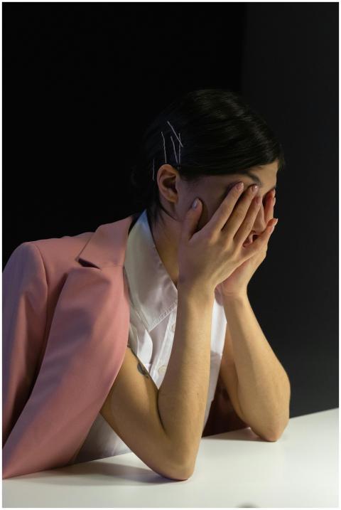 A stressed office worker in a pink jacket covering