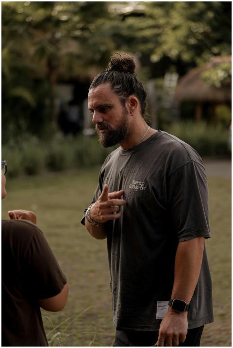 Man with bun hairstyle engaged in conversation out