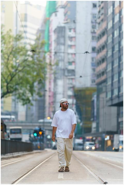Man strolls through busy Hong Kong street, surroun