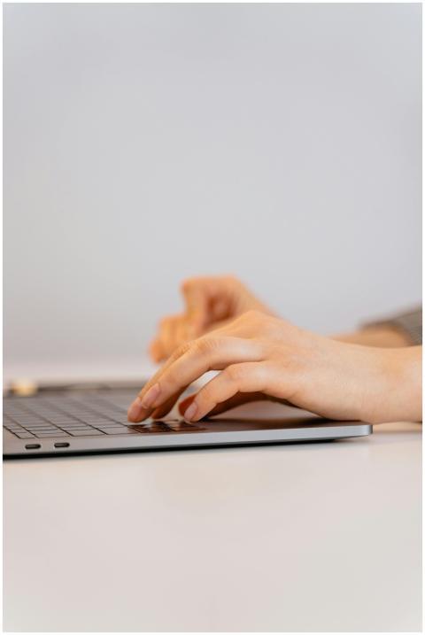 Hands typing on a laptop keyboard, focusing on dig