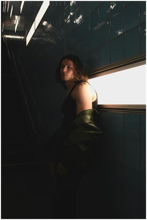 A moody portrait of a person in a dimly lit stairw