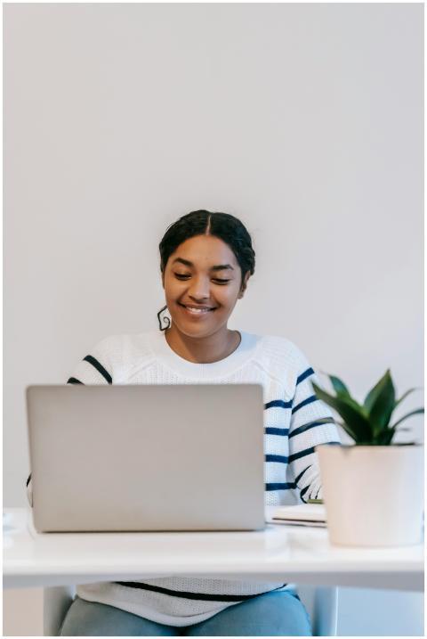 Smiling woman working remotely on a laptop in a co