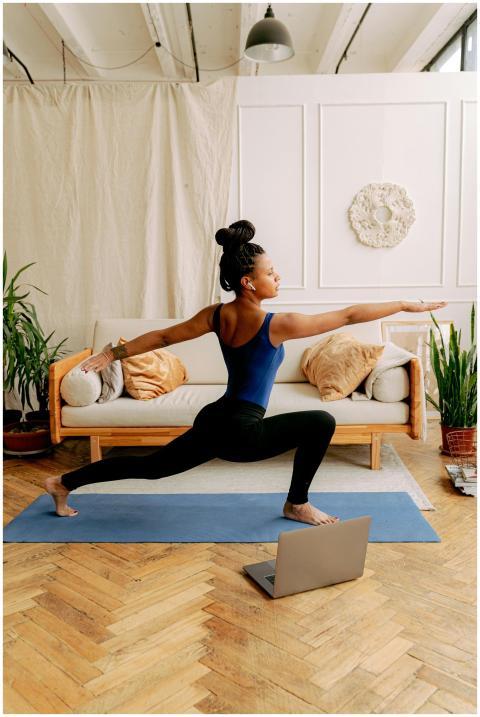 An African American woman performing the warrior p