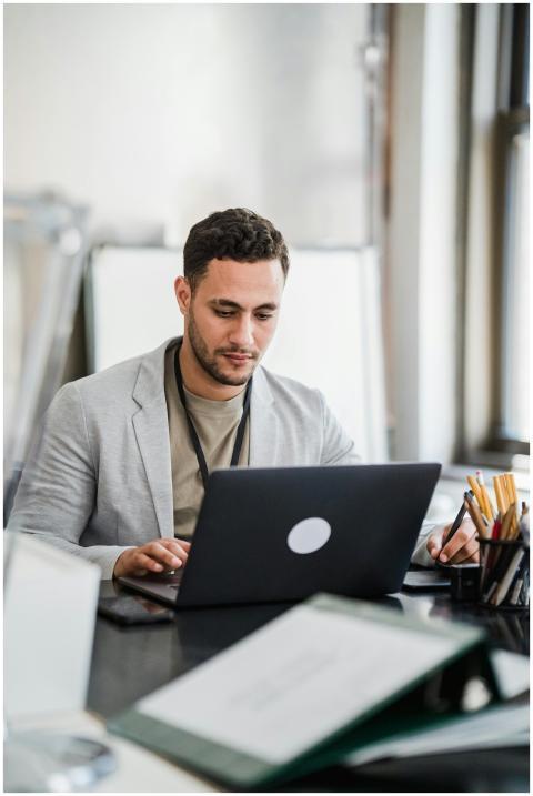 Focused man working on a laptop in a modern office
