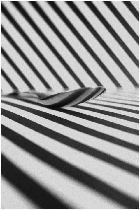 Black and white image of a spoon on a geometric st