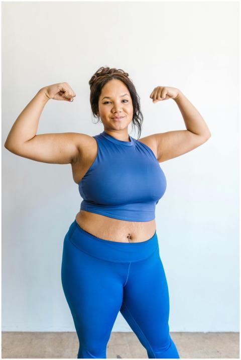 Plus-size woman in blue activewear confidently pos