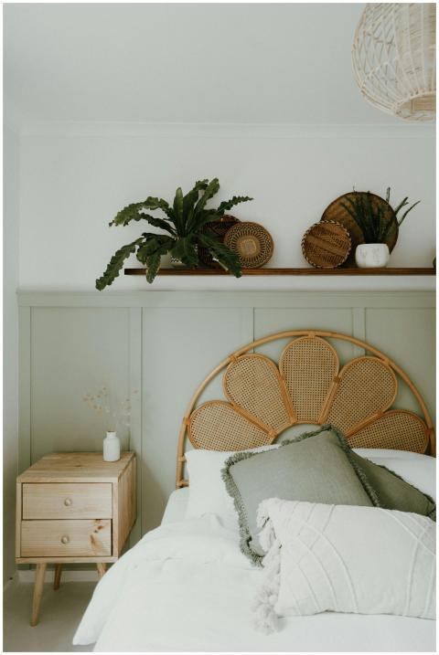 Cozy bedroom interior with wicker headboard and pl