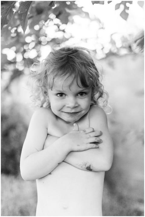 Black and white portrait of a smiling child outdoo