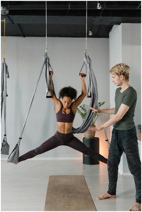 Woman practicing aerial yoga on a hammock with an
