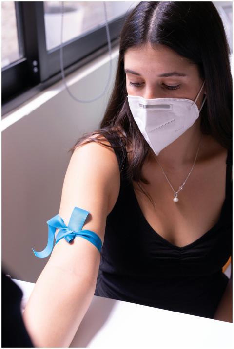 A woman wearing a face mask prepares for a blood t