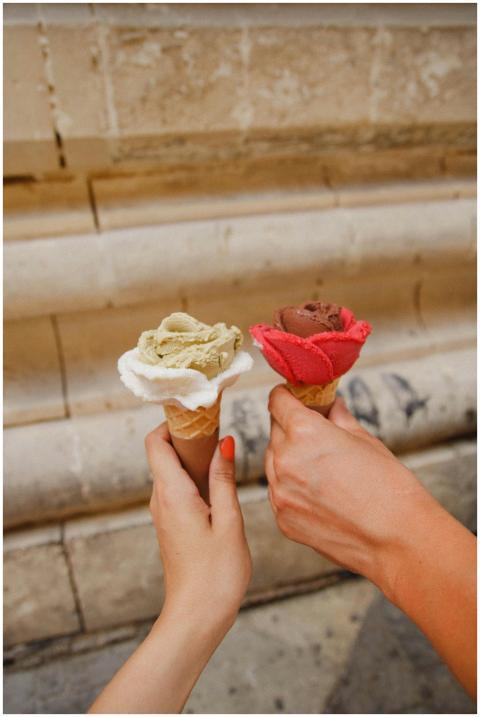 Two hands hold rose-shaped gelato cones in Malta,