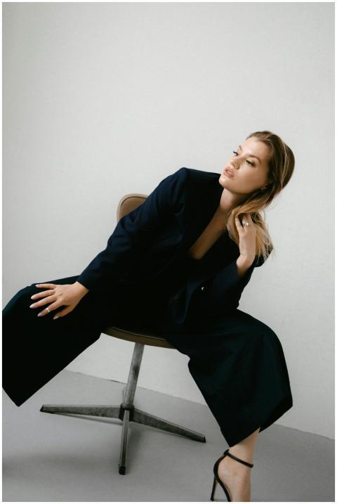 Chic and modern woman in a black blazer sits on a