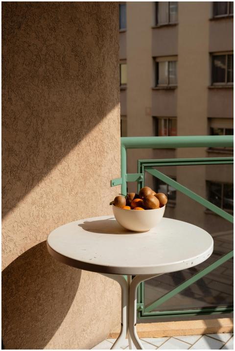 A serene balcony scene with a bowl of fresh fruit