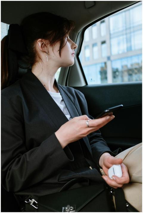 A woman with a ponytail and earrings uses a smartp
