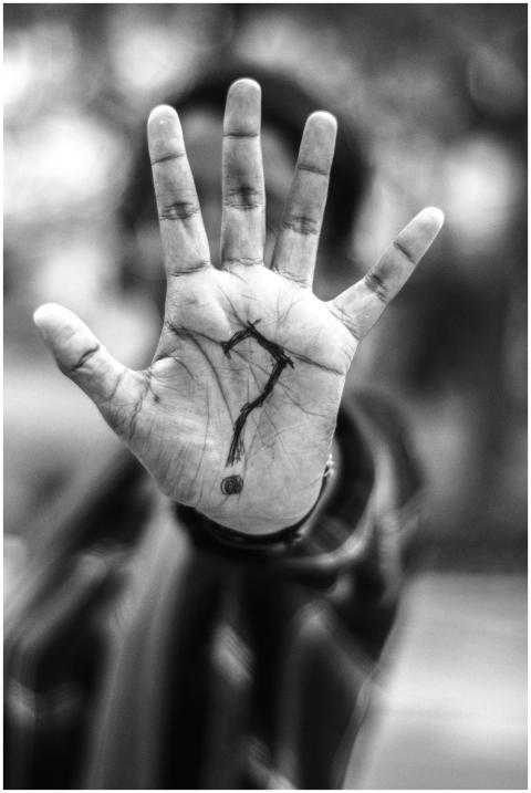 Monochrome image of a hand with tattoo art, creati