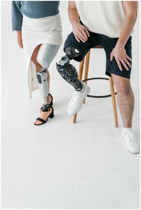 Two adults with prosthetic legs captured in a stud