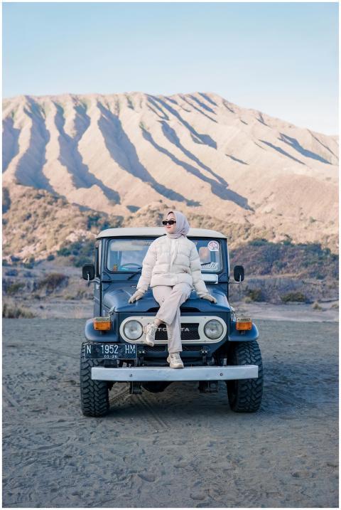 Adult woman in stylish outfit sits on a Jeep at Mo