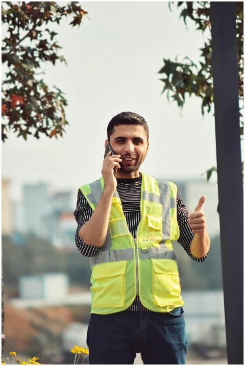 Young construction worker in a reflective vest tal