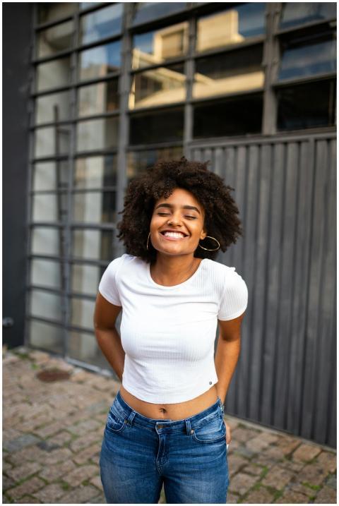 Smiling woman with curly hair in casual fashion en