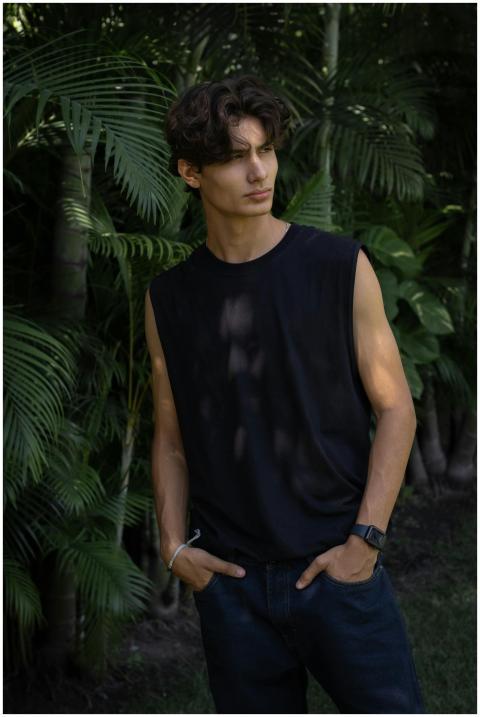 Stylish young man in casual black t-shirt stands c
