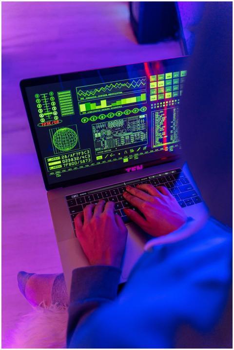 An unrecognizable person using a laptop indoors wi