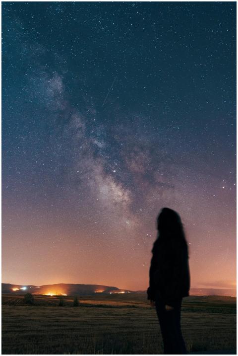 Silhouette of a woman gazing at the Milky Way in a