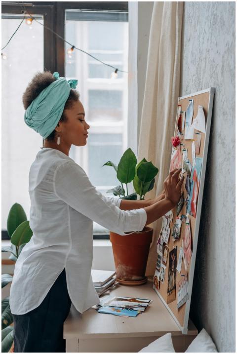 A woman working on a vision board indoors, surroun