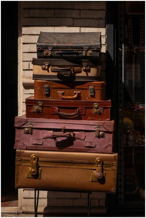 A stack of vintage suitcases outside on a bright d