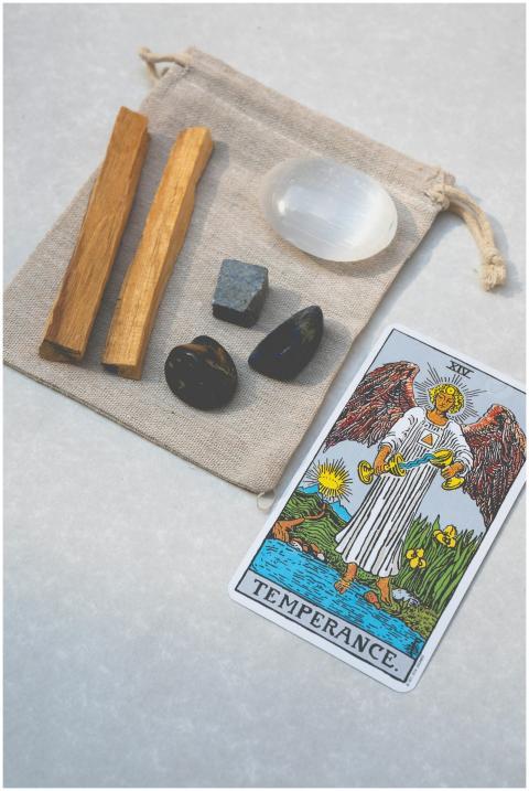Top view of tarot card and healing stones on a can
