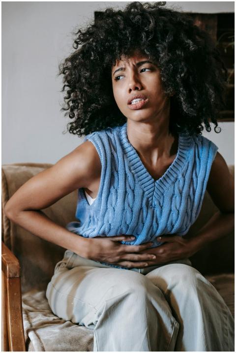 Young African American female sitting on couch at