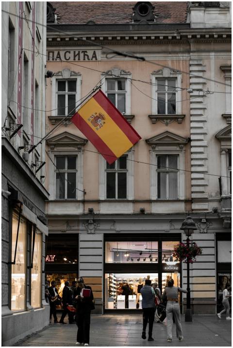 A lively street in Belgrade featuring a Spanish fl