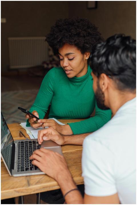 Two adults collaborating on a project at home with