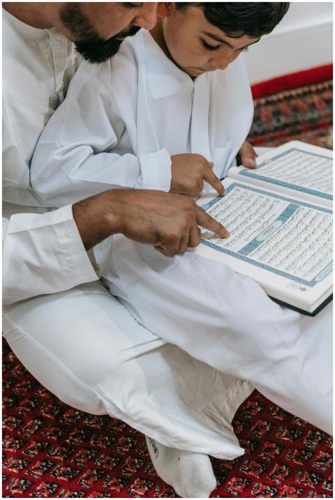 A father and son reading the Quran together, symbo