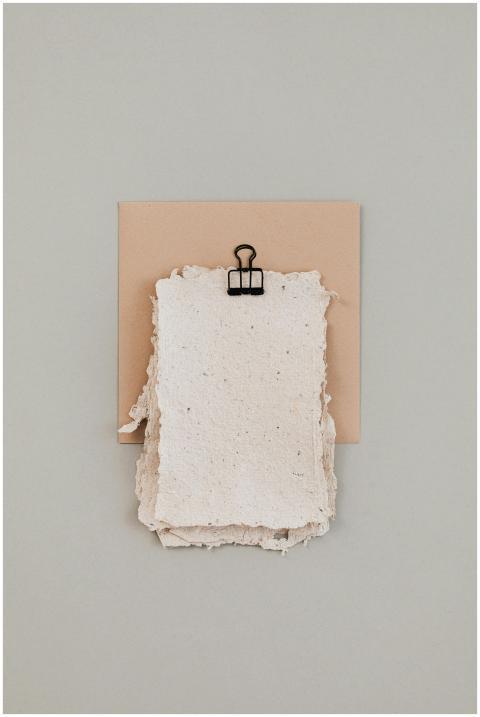 Elegant rustic paper sheets clipped on a soft beig
