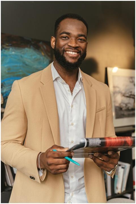 Smiling black businessman holding documents in a m