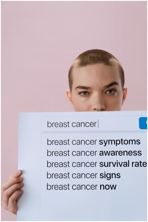 Woman holding a sign on breast cancer awareness wi